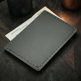 Gray leather wallet on a wooden surface with a blurred background