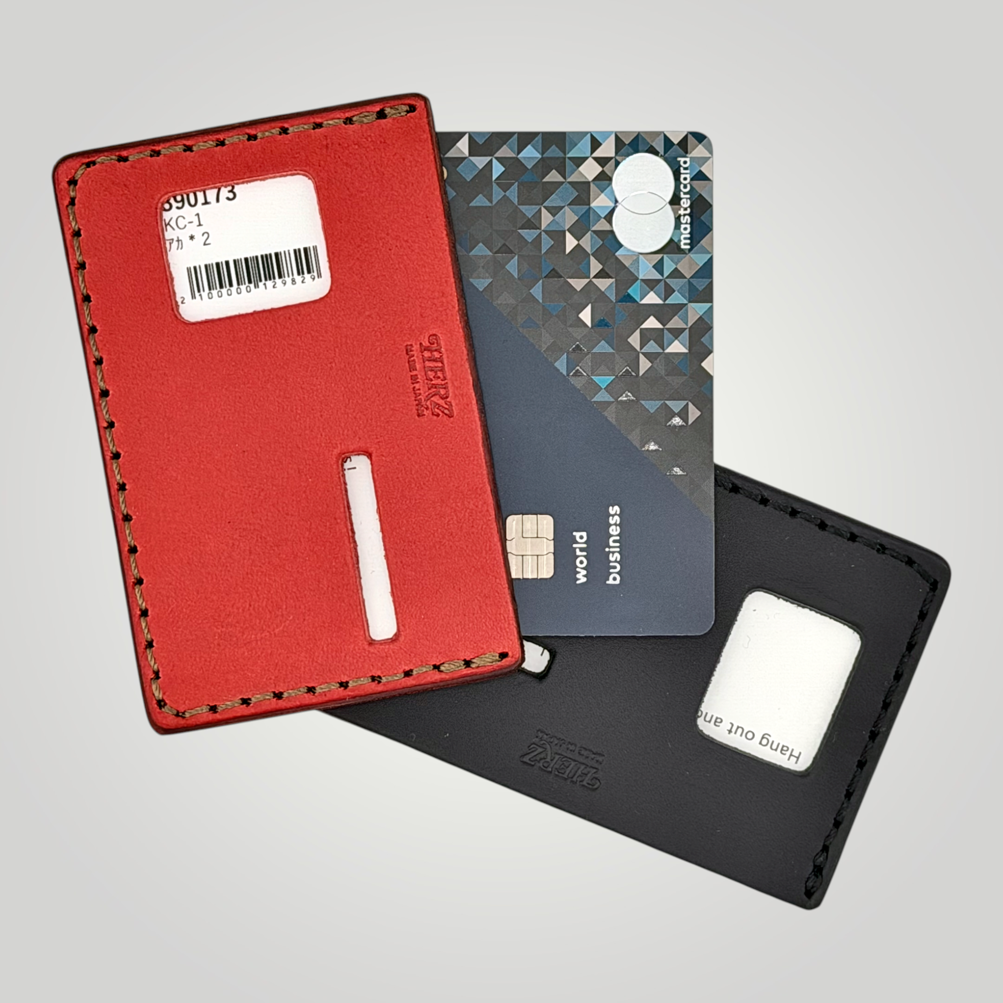 Red cardholder with a gray card and black cardholder on a light gray background