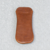 Brown leather eyewear case on a textured gray background