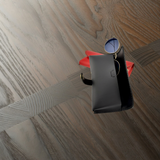 Black eyewear bag with red lining on a wooden surface