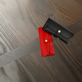 Red and black leather eyewear cases on a wooden surface