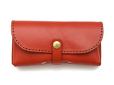 Red leather eyewear bag with a gold buckle on a white background