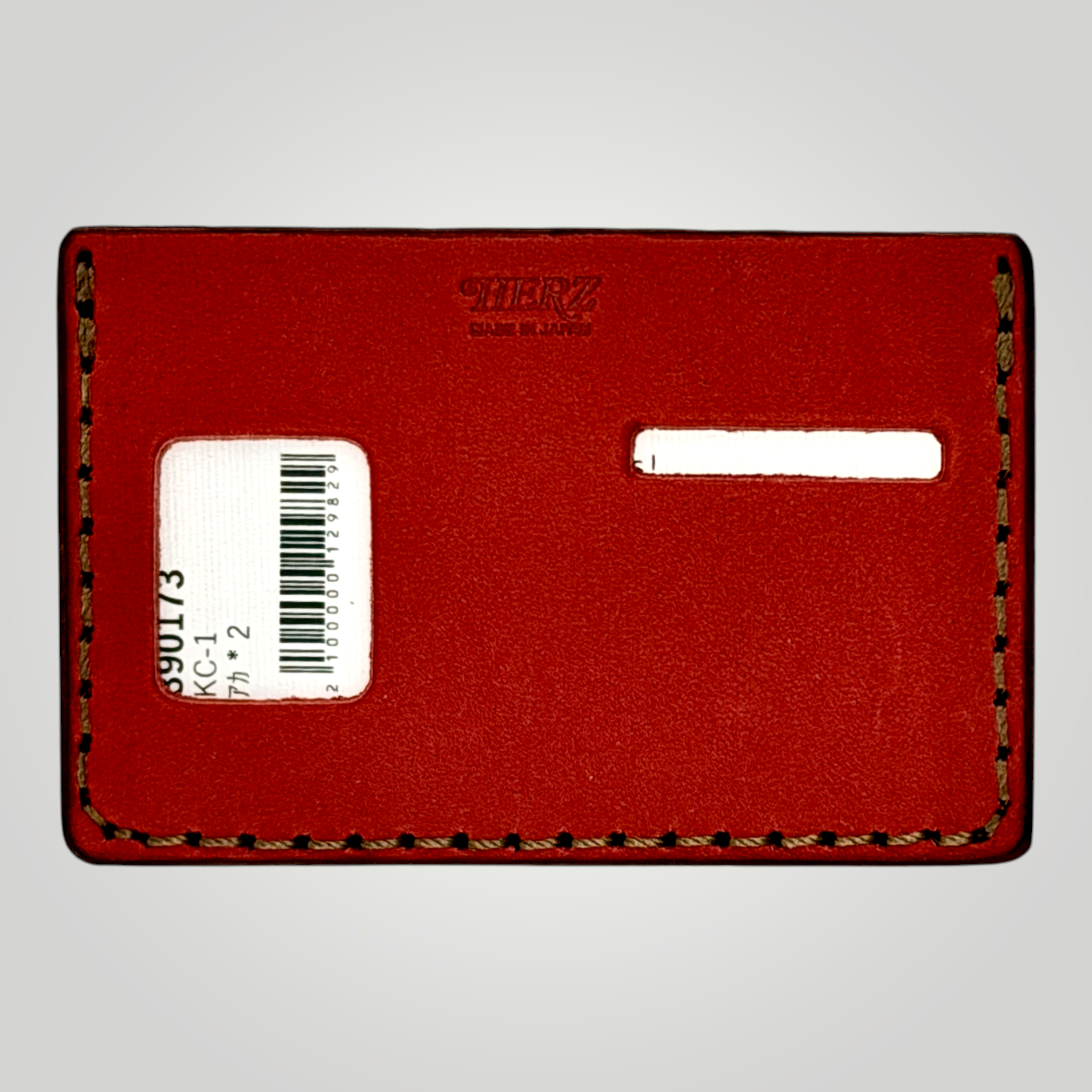 Red leather cardholder with a barcode label on a gray background