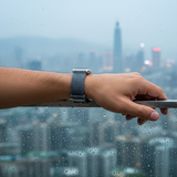 Hand holding a rain-soaked window with a cityscape in the background
